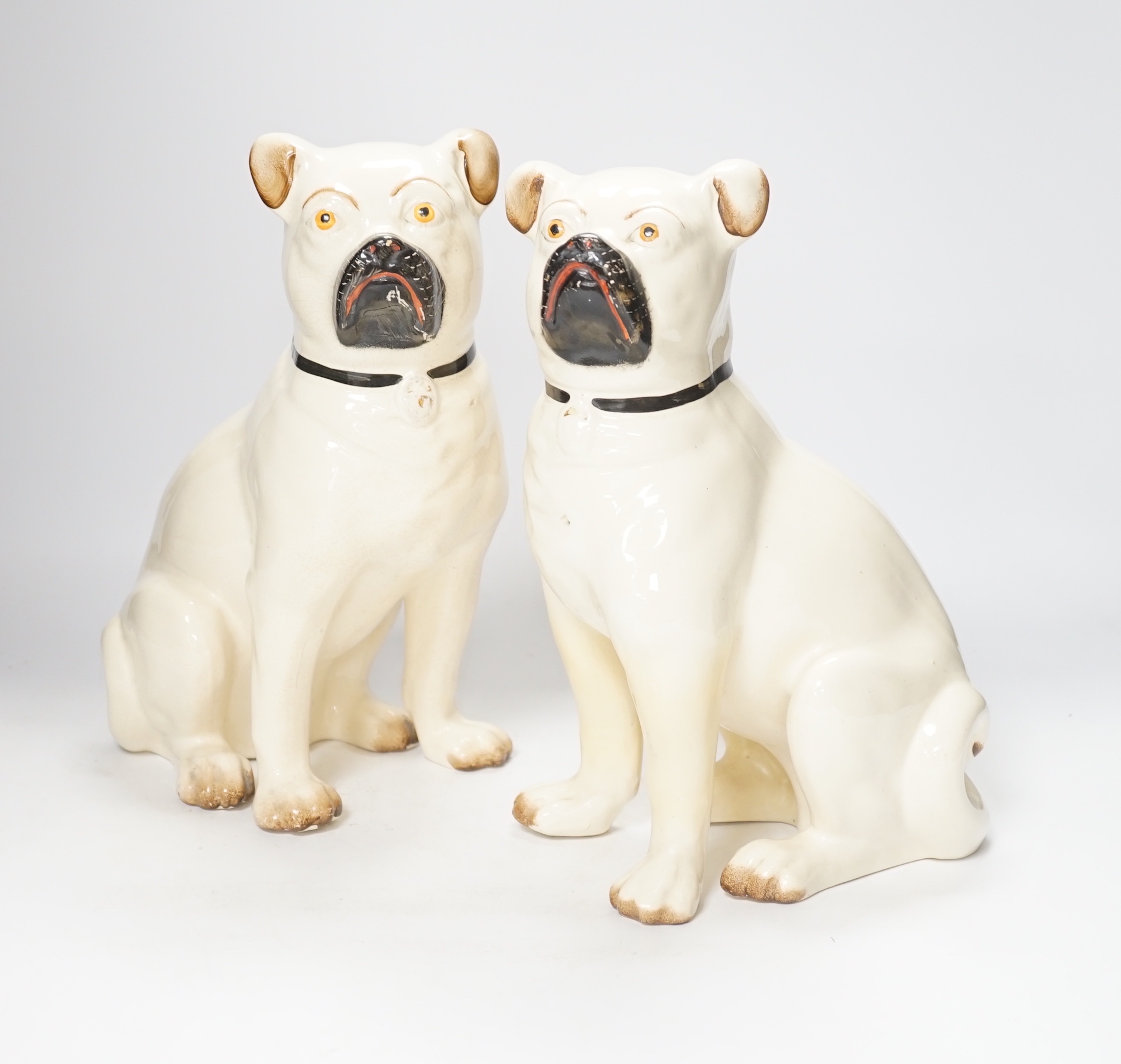 A pair of Staffordshire pug dogs, 28cm high